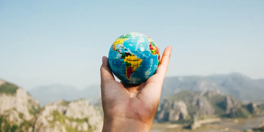 A hand holding a globe